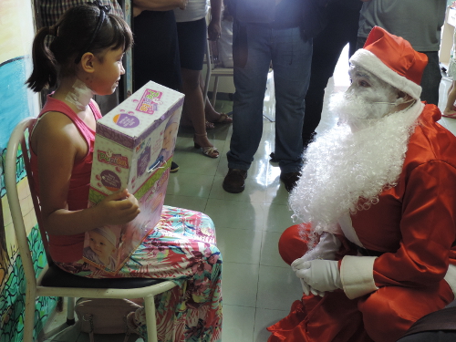Juliana Csucsuly recebendo boneca de presente do Papai Noel
