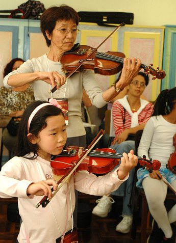 Shibonu em apresentação com crianças violinistas